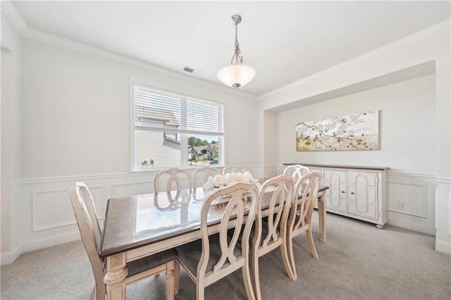 dining area featuring crown molding, visible vents, light carpet, and a decorative wall