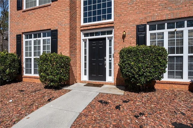 doorway to property with brick siding