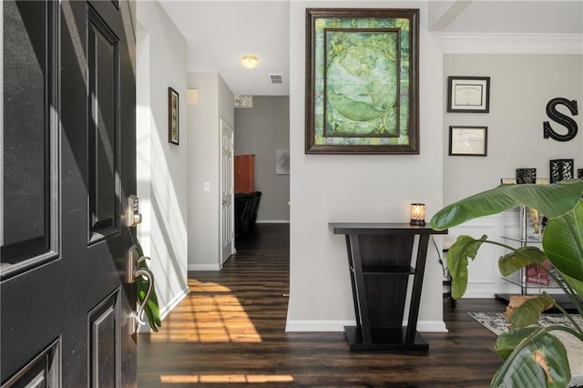 hall with visible vents, baseboards, dark wood finished floors, and crown molding