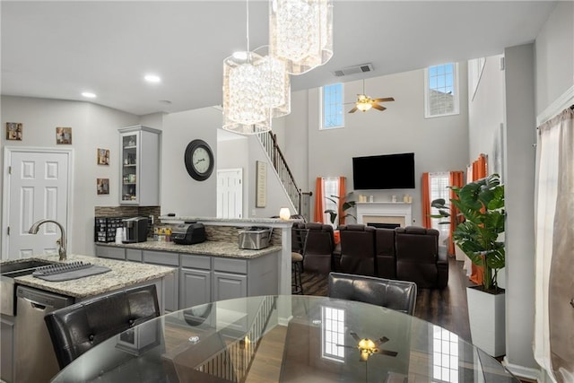 dining area featuring recessed lighting, visible vents, a fireplace, and ceiling fan with notable chandelier