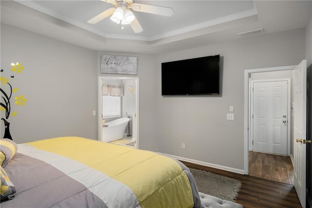 bedroom with ornamental molding, baseboards, a tray ceiling, and wood finished floors