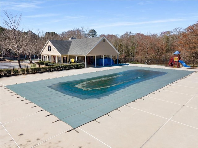 community pool featuring playground community, a patio, and fence