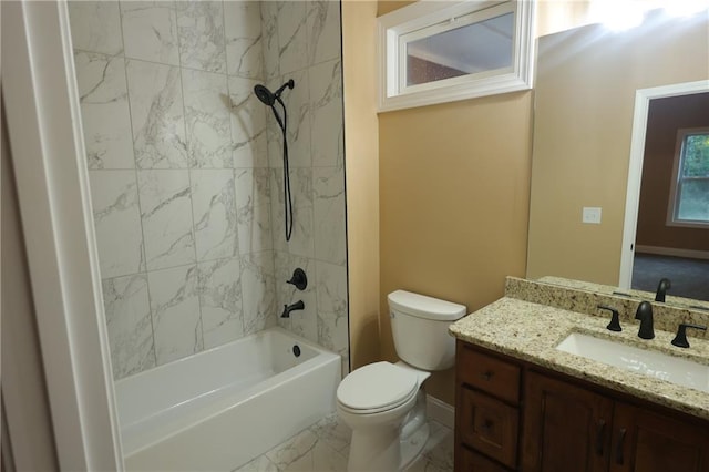 full bathroom featuring vanity, tiled shower / bath, and toilet