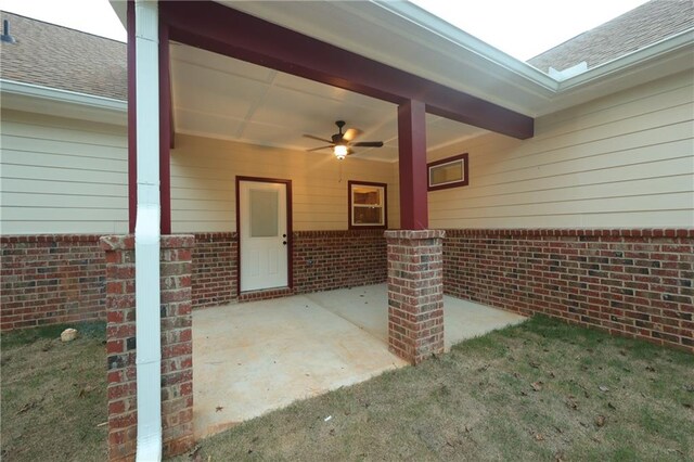 view of exterior entry featuring a patio area and ceiling fan