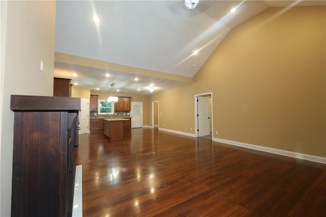 unfurnished living room featuring high vaulted ceiling and dark hardwood / wood-style flooring