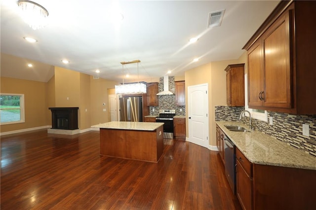 kitchen with backsplash, appliances with stainless steel finishes, a kitchen island, dark wood-type flooring, and sink