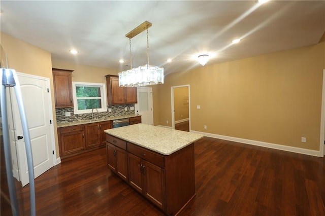 kitchen with stainless steel dishwasher, a center island, hanging light fixtures, and dark hardwood / wood-style floors