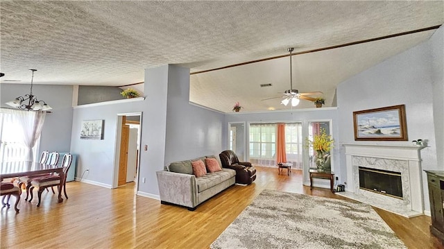 2233 Hansford Pass, Buford, GA 30519 - living room with lofted ceiling, a textured ceiling, a ceiling fan, a chandelier, and light wood-type flooring