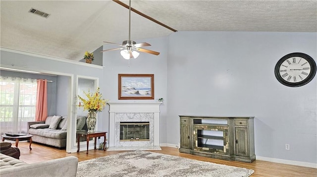 2233 Hansford Pass, Buford, GA 30519 - living room with a premium fireplace, a ceiling fan, vaulted ceiling, wood finished floors, and a textured ceiling