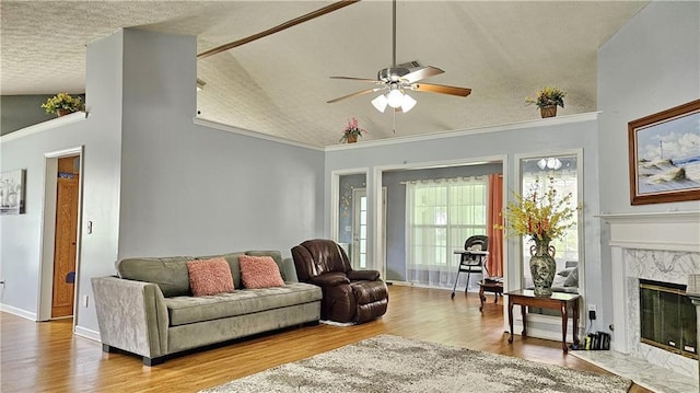 2233 Hansford Pass, Buford, GA 30519 - living room with a ceiling fan, lofted ceiling, a textured ceiling, wood finished floors, and a premium fireplace