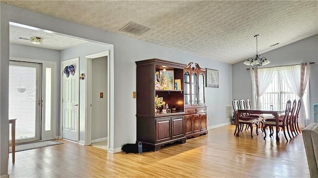 2233 Hansford Pass, Buford, GA 30519 - dining space with a chandelier, a textured ceiling, light wood-type flooring, and vaulted ceiling