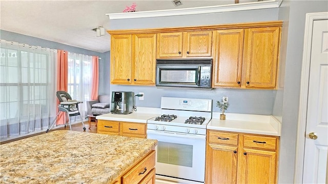2233 Hansford Pass, Buford, GA 30519 - kitchen featuring black microwave, white gas stove, and light countertops