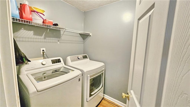 2233 Hansford Pass, Buford, GA 30519 - laundry area featuring washer and clothes dryer, a textured ceiling, and wood finished floors