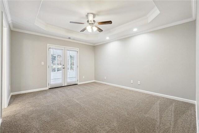 carpeted spare room with crown molding, french doors, a raised ceiling, and baseboards