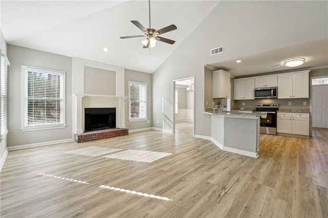 20 Trace Ct, Covington, GA 30016 - kitchen with stainless steel appliances, plenty of natural light, high vaulted ceiling, light wood-style flooring, and a ceiling fan