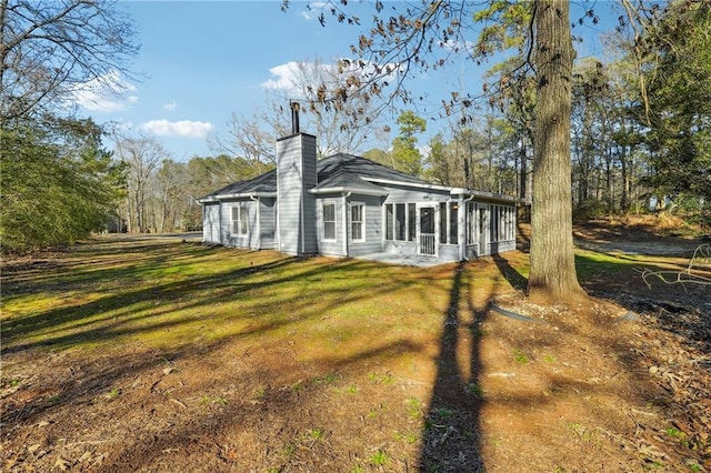 20 Trace Ct, Covington, GA 30016 - rear view of house featuring a sunroom, a chimney, and a yard