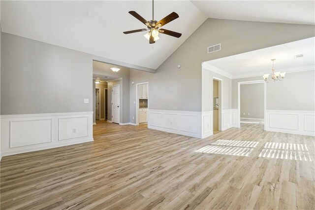 unfurnished dining area featuring light wood-type flooring, crown molding, and ceiling fan with notable chandelier