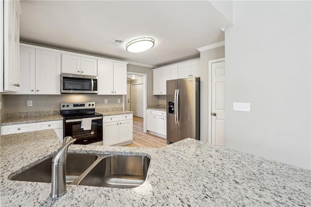 20 Trace Ct, Covington, GA 30016 - kitchen featuring stainless steel appliances, crown molding, a sink, white cabinets, and light stone counters
