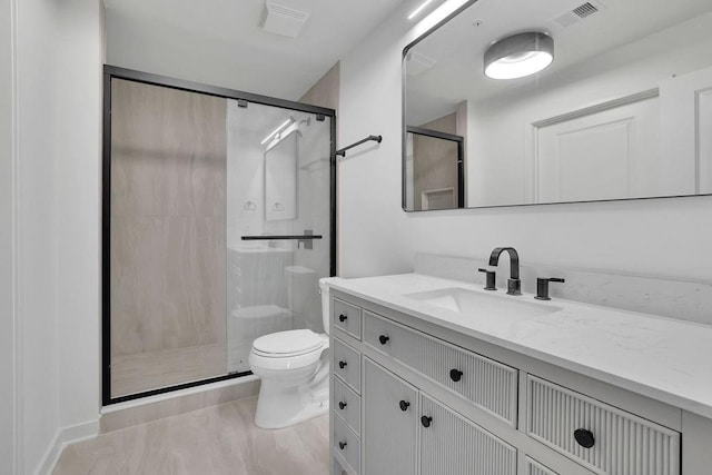 bathroom featuring vanity, an enclosed shower, and toilet