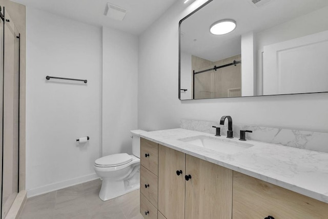 bathroom featuring vanity, tile patterned flooring, toilet, and walk in shower