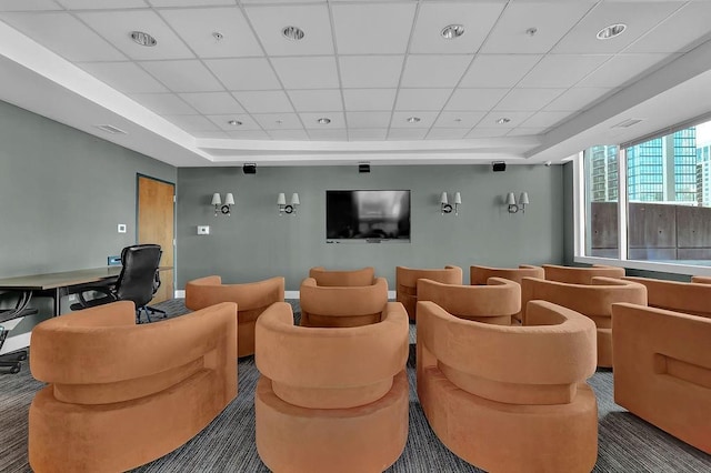 cinema room featuring a paneled ceiling and dark carpet