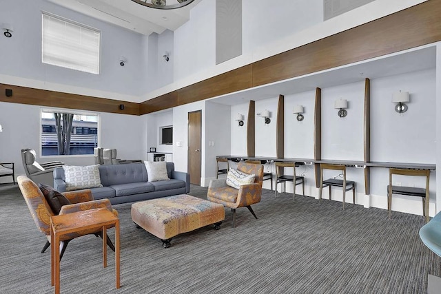 living room featuring a towering ceiling and carpet flooring