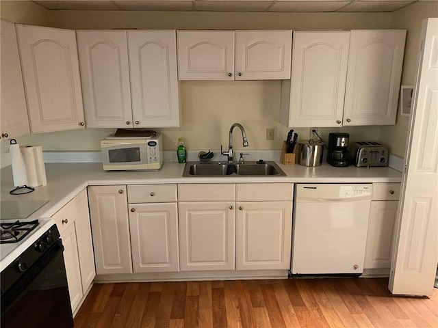 kitchen with white cabinets, white appliances, and sink