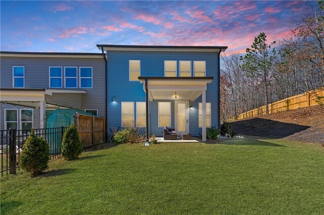 6240 Merrill View Ln, Alpharetta, GA 30004 - back house at dusk with a lawn and a patio