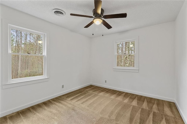 carpeted empty room featuring plenty of natural light and ceiling fan