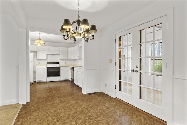 kitchen with dark parquet floors, white cabinetry, white appliances, and a chandelier