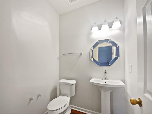 half bath with baseboards and toilet