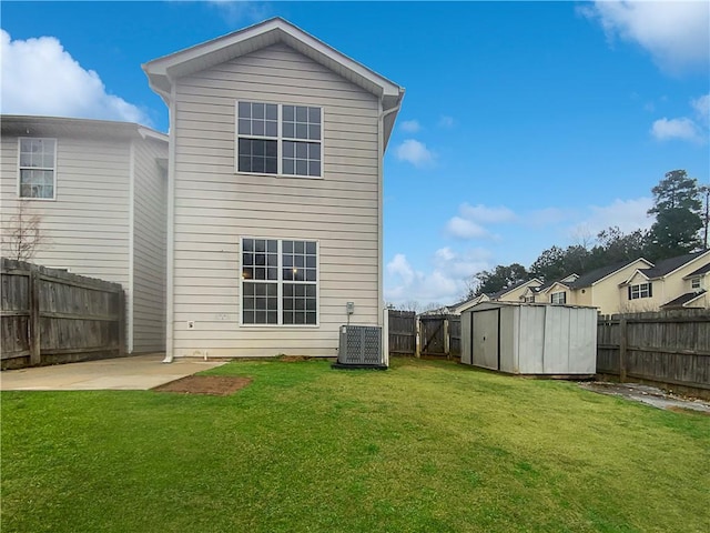 back of house with a yard, a patio, a storage shed, a fenced backyard, and an outdoor structure