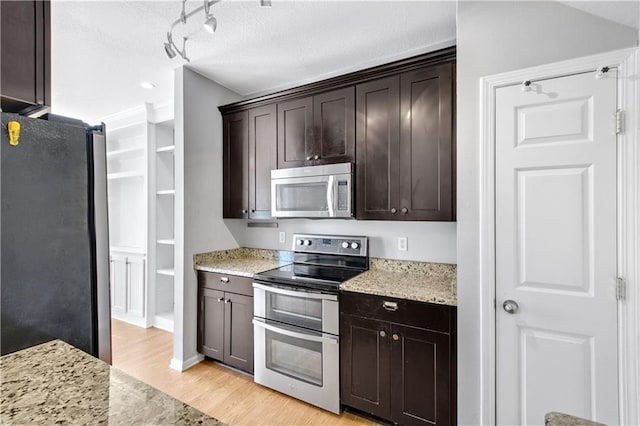 kitchen with dark brown cabinetry, light stone countertops, appliances with stainless steel finishes, and light wood-style floors