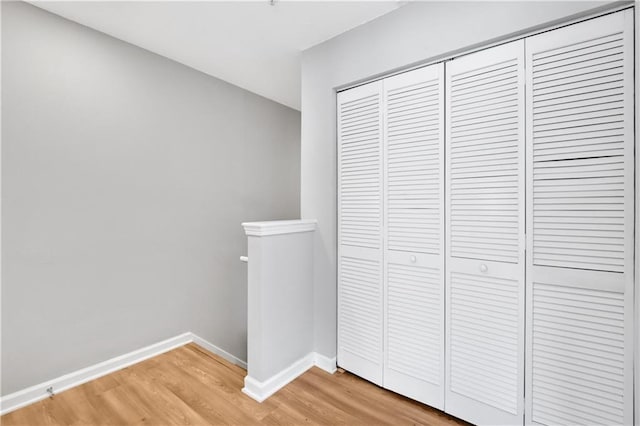 interior space featuring baseboards, a closet, and wood finished floors