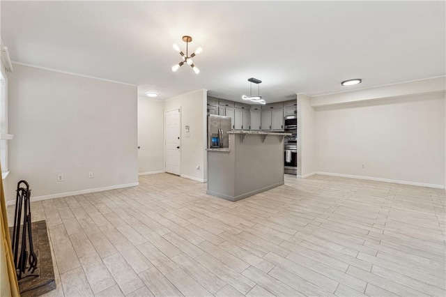 kitchen featuring gray cabinets, light wood-style floors, open floor plan, and appliances with stainless steel finishes