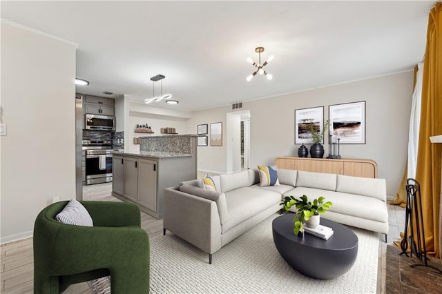 living area featuring visible vents, an inviting chandelier, light wood-style flooring, and baseboards