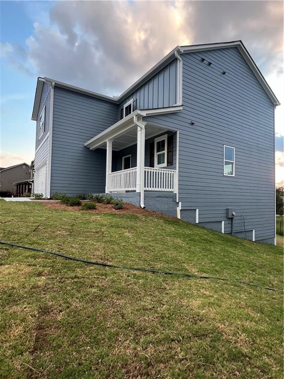 rear view of house with a yard and covered porch