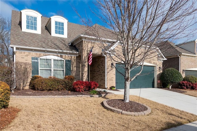 view of front of home featuring brick siding, a shingled roof, a front lawn, a garage, and driveway