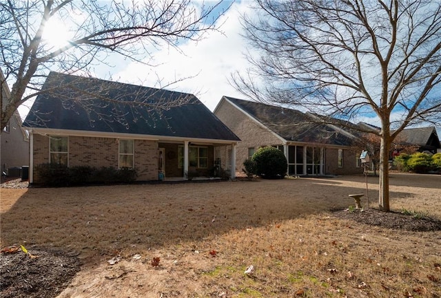 back of house featuring brick siding and central AC