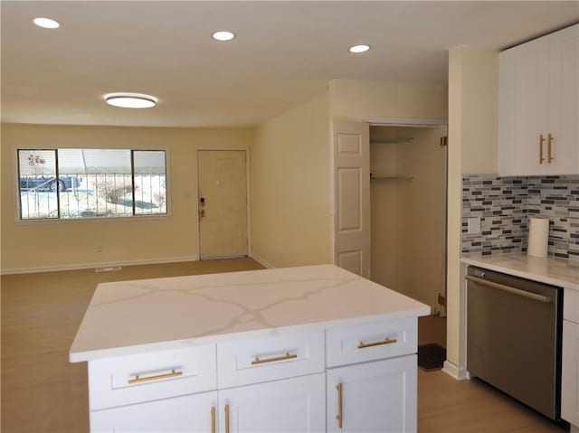 kitchen with white cabinets, backsplash, stainless steel dishwasher, and recessed lighting