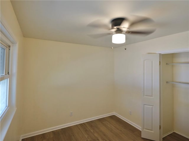 unfurnished bedroom featuring ceiling fan, dark wood-style flooring, a closet, and baseboards