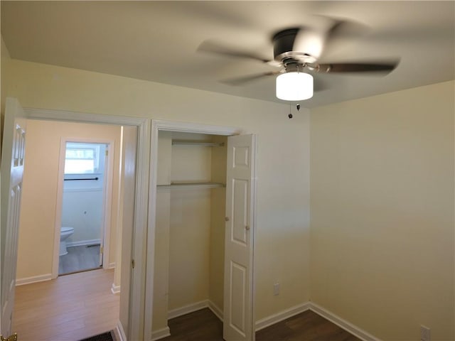 interior space featuring dark wood-style flooring, a closet, and baseboards