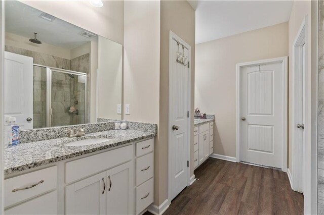 663 Wheeler Rd, Demorest, GA 30535 - full bath featuring baseboards, a sink, a shower stall, wood finished floors, and two vanities