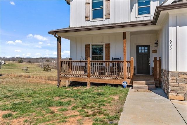 view of exterior entry featuring board and batten siding and a porch