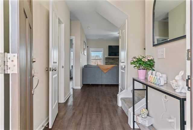 corridor featuring dark wood-style flooring, visible vents, and baseboards