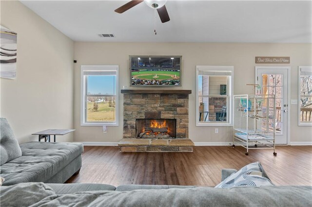 663 Wheeler Rd, Demorest, GA 30535 - living room with baseboards, a stone fireplace, a ceiling fan, visible vents, and wood finished floors