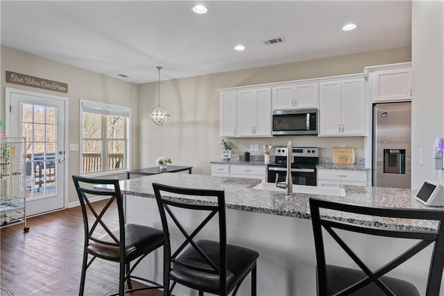 663 Wheeler Rd, Demorest, GA 30535 - kitchen featuring stainless steel appliances, visible vents, white cabinets, and a kitchen bar