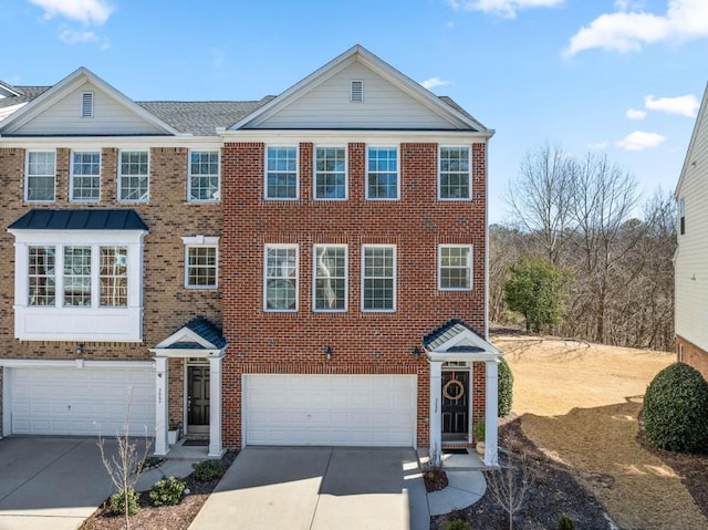 multi unit property with a garage, concrete driveway, and brick siding