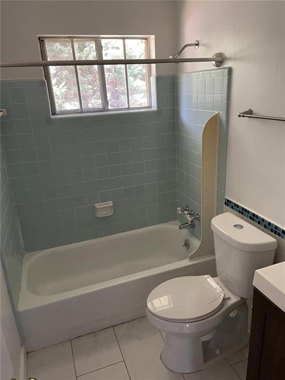 full bathroom featuring a wealth of natural light, toilet, vanity, and tiled shower / bath