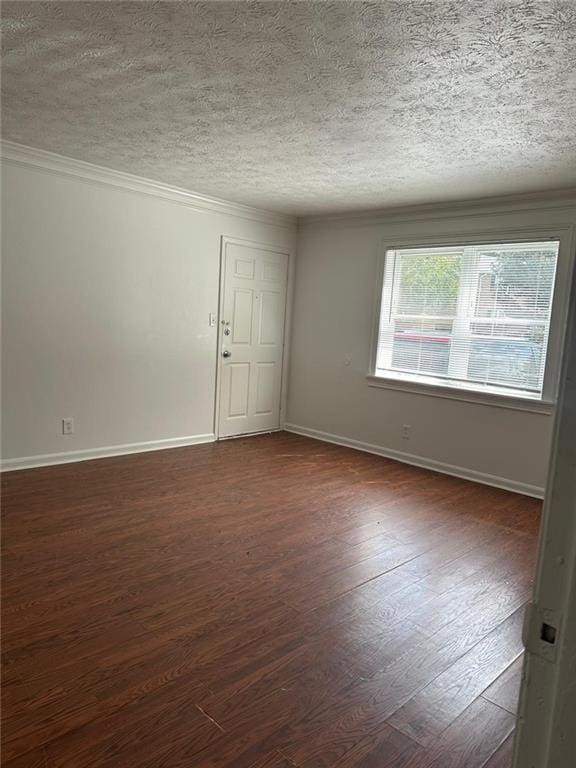 unfurnished room featuring a textured ceiling, crown molding, and dark wood-type flooring